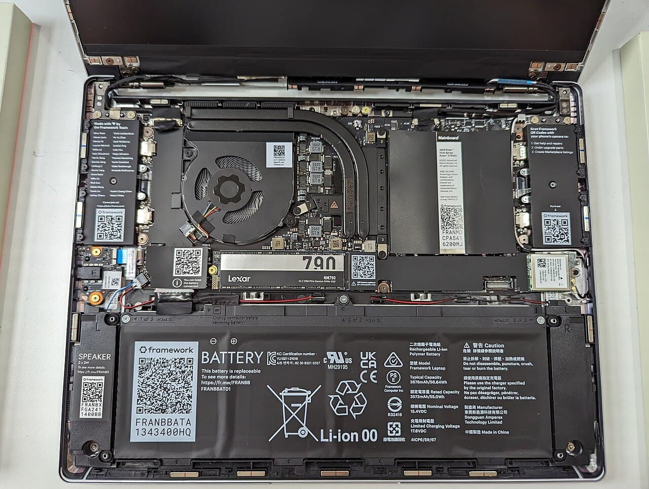 Inside an opened laptop: fan, SSD, RAM and battery
